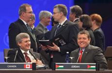 [Prime Minister Stephen Harper and Abdullah II Bin Al-Hussein, the King of Jordan, share a laugh while waiting for the afternoon plenary session at the Nuclear Security Summit in Washington, DC] 13 April 2010