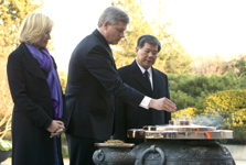 [Prime Minister Stephen Harper and his wife Laureen Harper drop incense into the burner at the Seoul National Cemetery] 7 December 2009