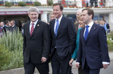 [Prime Minister Stephen Harper walks to the opening session with British Prime Minister David Cameron, German Chancellor Angela Merkel and Russian President Dmitry Medvedev at the G8 Summit in Deauville, France] 26 May 2011