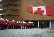 [Prime Minister Stephen Harper helps lower a Canadian flag in front of the construction workers who helped build the Canada Pavilion at the Shanghai 2010 Exposition Site] 4 December 2009