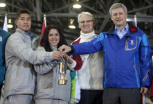 [Olympic Flame carriers Aronhiaies Herne and Dina Ouellette hold the flame with Prime Minister Stephen Harper and British Columbia Premier Gordon Campbell marking the start of the Olympic Torch Run in Victoria, British Columbia] 30 October 2009