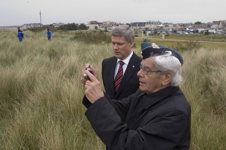 [D-Day veteran Sam Garnet, 85, of Montréal takes a few photos with Prime Minister Stephen Harper as they walk on Juno Beach following the 65th D-Day ceremony in Courseulles-sur-Mer, France] 6 June 2009