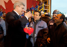 [Prime Minister Stephen Harper signs a Team Canada hat for a worker from Seaspan Vancouver Shipyard after an announcement in Vancouver, British Columbia] 12 January 2012