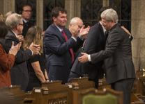 [Prime Minister Stephen Harper hugs Justin Trudeau after delivering remarks in the House of Commons addressing the attacks in the nation's capital] 23 October 2014