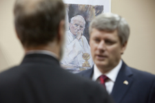 [A painting of Pope Jean-Paul II hangs in the background as Prime Minister Stephen Harper chats with Father Borys Gudziak, Rector of the Ukrainian Catholic University in Lviv, Ukraine] 26 October 2010