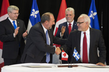 [Prime Minister Stephen Harper and Philippe Couillard, Premier of Quebec, witness the signing of the Gas Tax Fund Administrative Agreement by Denis Lebel and Carlos Leitão, Quebec Minister of Finance in Roberval, Quebec] 25 June 2014