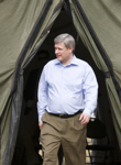 [Prime Minister Stephen Harper emerges from a tent in order to greet Haitian Prime Minister Jean-Max Bellerive and Haitian President René Préval in Port-au-Prince, Haiti] 15 February 2010