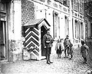 The children of the newly captured villages are very interested in British Tommy on sentry go. May, 1917 May, 1917.