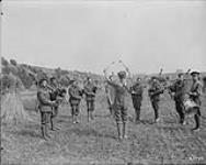 A Canadian Pipe Band practising in a corn field. August, 1917 Aug., 1917.