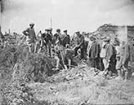 The Mayor, Aldermen and prominent business men of Souchez return after two years to dig for their money buried by the French before evacuating. August, 1917 Aug., 1917.