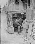 A Canadian Sentry in his sentry box of ammunition boxes, etc Sep., 1917.