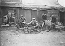 Armourer Sergeant and Staff of the Canadian Motor Machine Gun Brigade repairing guns. April, 1918 Apr., 1918