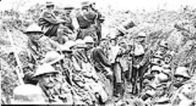 Canadians and prisoners take cover in a trench during the advance east August, 1918.