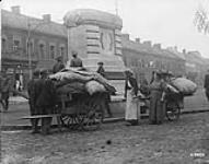 Civilians released by Canadians passing through Denain [France] stop and look where a huge bronze statue of Marshal Villars once stood. The bronze horse, rider and inscription plates were taken away by retreating enemy. October, 1918 October 1918.
