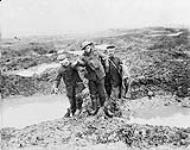 Canadian and German wounded help one another through the mud during the capture of Passchendaele. Nov., 1917.
