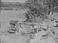 Snipers using water wheels - wheel with single row of empty cans, Quesnel River, B.C 1938