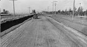Low cost road construction in Saskatchewan. Finished surface being compacted by traffic. 1930