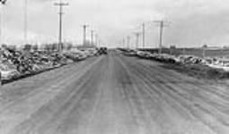 Low cost road construction in Saskatchewan. Finished surface being compacted by traffic. 1930