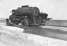 Low cost road construction in Saskatchewan. Distributor applying first bituminous treatment. 1930