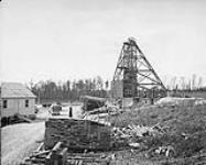Halnor Mine. - New steel head frame under construction and portions of Timber Yard. Porcupine, Ontario 1936