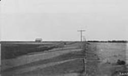 Soil drifted along a fence and telephone line [Sask.] 1920