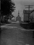 Main street and church, St. Célestin, P.Q 1924