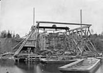 Construction of the Miramichi Bridges on the Intercolonial Railway. South West Branch. Front view of westerly abutment from Pier E, with gantrey staging and traveller/Construction des ponts de Miramichi sur l'Intercolonial. Vue frontale de la butee ouest 1872-1873