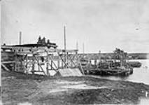 Construction of the Miramichi Bridges on the Intercolonial Railway. South West Branch. View of westerly abutment and staging for Pier E and F, caisson of Pier E in process of sinking/Construction des ponts de Miramichi sur l'Intercolonial. Embranchement 1872-1873