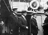(L-R:)Inspector Reid, H.H. Stevens and Capt. Walter J. Hose on board the "Komagata Maru" in English Bay, Vancouver, British Columbia 1914