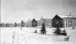 (Relief Projects - No. 81). East row of ordnance stores and completed bunkhouses with one under construction Nov. 1933