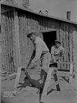 (Relief Projects - No. 103). [Relief personnel sawing wood] July 1935