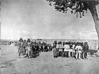 Tablita dancers (at left) and singers (at right) in a ceremony for the purpose of bringing rain-clouds; San Ildefonso, [in the Valley of the Rio Grande, New Mexico] 1926