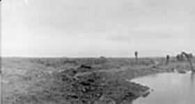 German prisoners and wounded Canadians coming through the mud. Battle of Passchendaele. November, 1917 November, 1917.