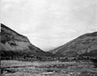 View (Northward) looking toward gap between Turtle and Goat Mountains, showing Slide and town of Frank, Alta [1903], 1911