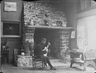 George A. Reid, artist, in front of his studio fireplace (Copy) 1893