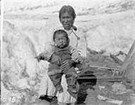 Inuit woman and child. The woman is smoking a pipe. Wakeham Bay 1928.