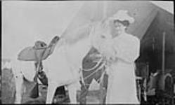 Mrs. Austin Bain Gillies née Jessie McCann standing beside a white horse n.d.
