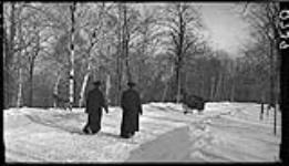 Sleigh driving up mountain with two priests walking down 5 Mar. 1914