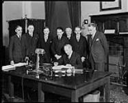 Signing of Money Order Agreement between Canada and France (including Algeria), in the Postmaster General's Office at Ottawa, Ont. Mr. Sauvé, Postmaster General of Canada is signing the agreement 17 Apr. 1935