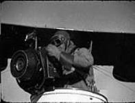 Photographer using aerial camera in Canadian Vickers Varuna II flying boat of the R.C.A.F ca. 1928