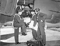 Men inside and outside airplane discussing ca. 1947