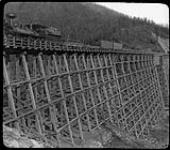 Canadian Pacific Railway locomotive no. 132 crossing the Mountain Creek Bridge near Summit, B.C. [ca. 1885-1900].