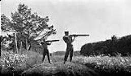 Two men holding [Lewis] machine guns in their hands, Niagara Camp 28 June, 1916