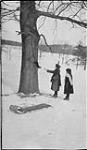 Two girls feeding a black squirrel, 17 Feb., 1918 17 Feb. 1918