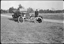 Changing a tire while automobiling in York Mills, [Ont.] 14 April, 1918 14 April 1918