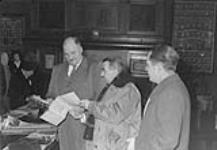 (Peace Campaign) Walter Tucker, leader opposition (left) talking to E.R. Franklin & F.J. Anderson of Regina Peace Council in Legislative Library Mar. 1951
