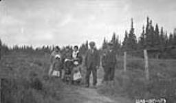 [Cree men, women, and children] Original title: Group of Indians July 1927.