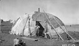 [Cree boy with a dog in camp] Original title: Indian Camp July 1927.