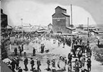 [Unidentified parade in Grenfell, [Sask.]. Grain Elevator in background] 1894-1905