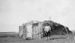 [Inuk standing in front of a topek] Original title: Native house 1924